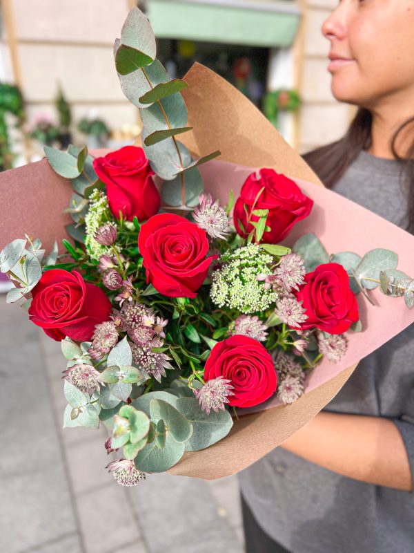 Ramo de seis rosas rojas sostenido por una trabajadora de BonBee.
