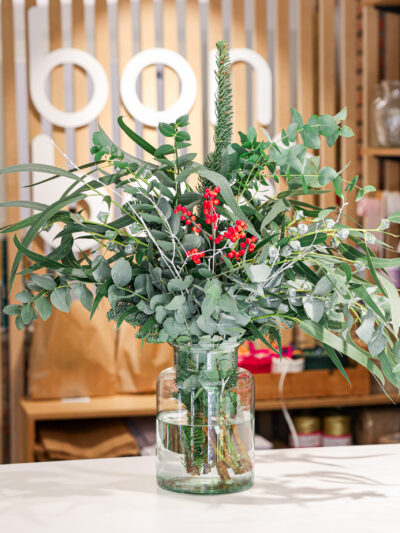Ramo de verdes navideños en un jarrón de cristal