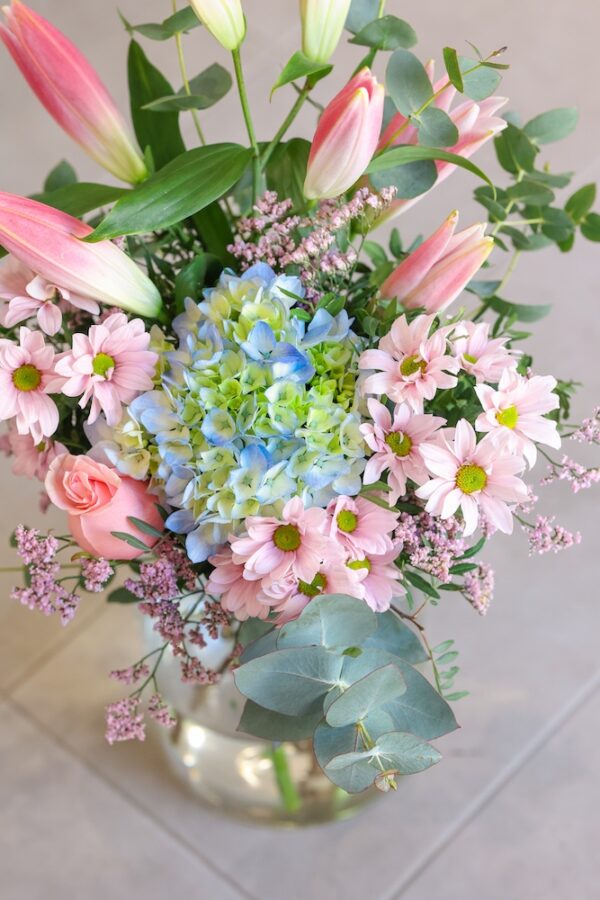 Ramo Chloë, que contiene hortensia azul, lilium oriental, crisantemos y una rosa.