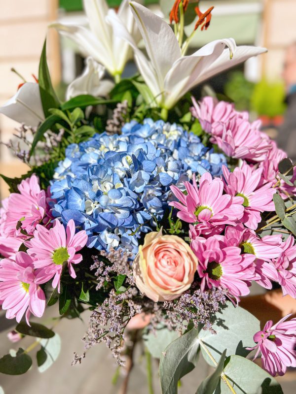 Ramo de flores con hortensia azul, dos varas de crisantemo rosado, una rosa rosada y lilium oriental de color blanco.