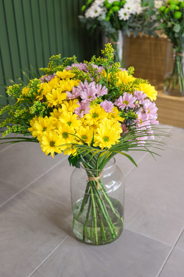 Ramo de crisantemos de color amarillo y violeta con solidago amarillo.