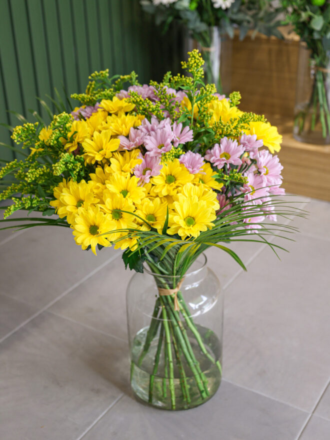 Ramo de crisantemos de color amarillo y violeta con solidago amarillo.