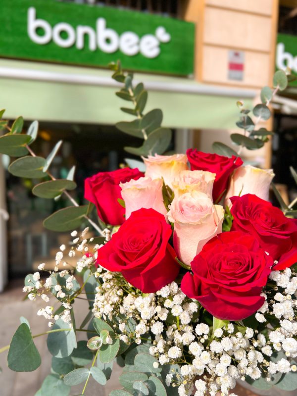 Ramo de flores de diez rosas de colores rojo y rosado con eucaliptus y paniculata.