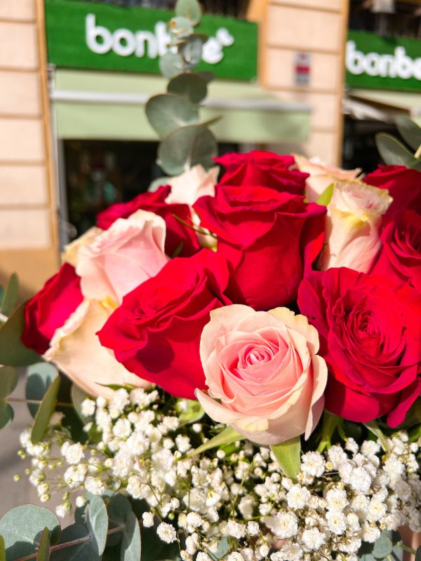 Ramo de flores de diez rosas de colores rojo y rosado con eucaliptus y paniculata.