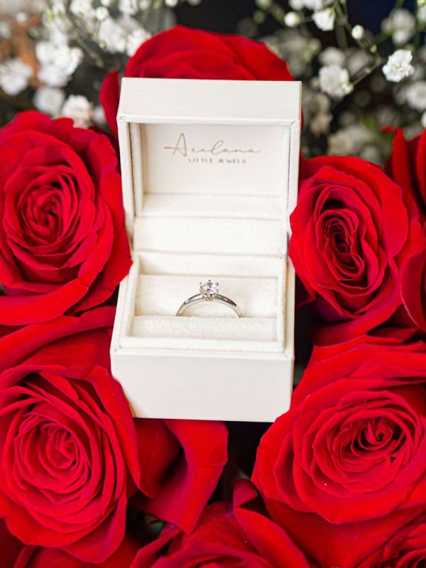 Anillo de pedida Arelana sobre lecho de rosas rojas