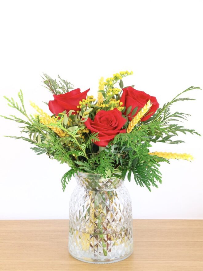 Ramo de 3 rosas rojas en jarrón de cristal.