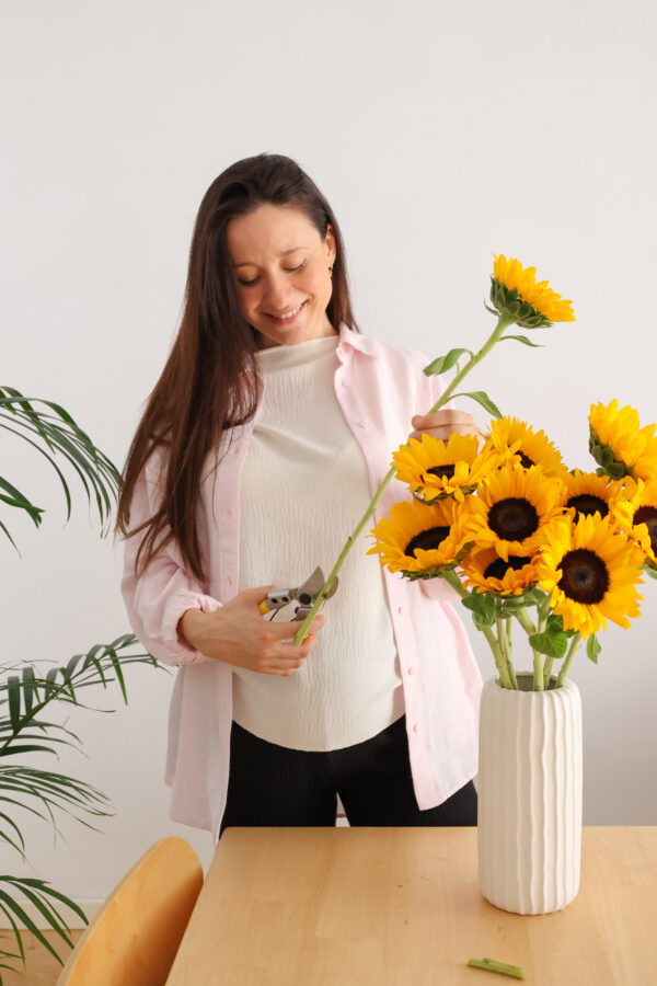 Mujer cortando girasoles para ponerlos en un jarrón