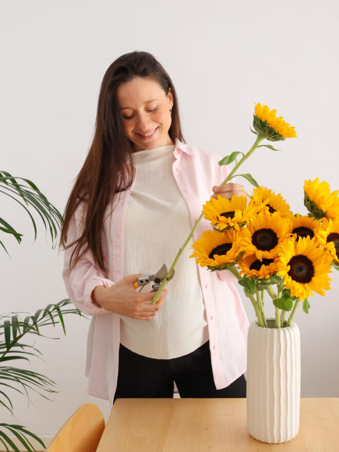 Mujer cortando girasoles para ponerlos en un jarrón