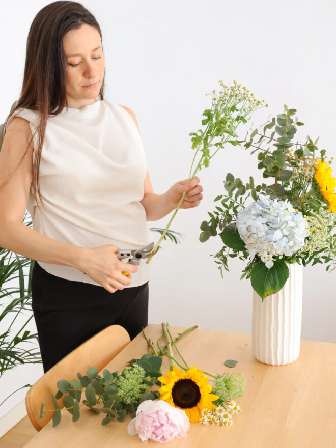 Mujer embarazada preparando un ramo de flores con sus manos