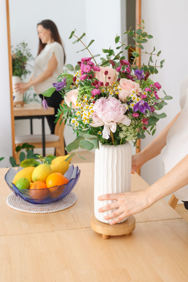 Ramo de flores variado de suscripción encima de mesa de madera