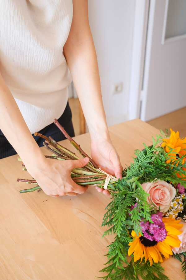 Mujer cogiendo un ramo con las manos encima de la mesa