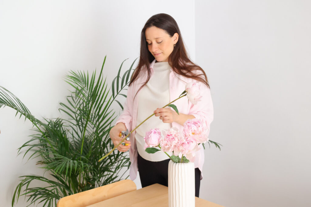 Preparando flores rosas en un jarrón en casa